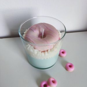 Vela de postre hecha con cera de soja de manera artesanal. Con forma de postre de nata con una rosquilla.